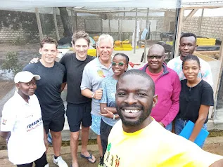 The HERI BSF Farm team with visitors in front of the larvae trays